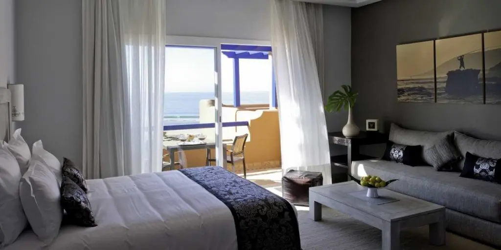 Chambre hôtel Paradis Plage Surf Yoga & Spa Resort Agadir. Lit double avec sofa , terrasse et  vue sur la plage.