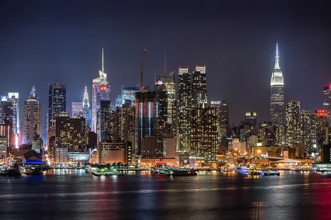Aperçu de la ville de New-York la nuit . Building éclairés face à une immense étendue d'eau.
