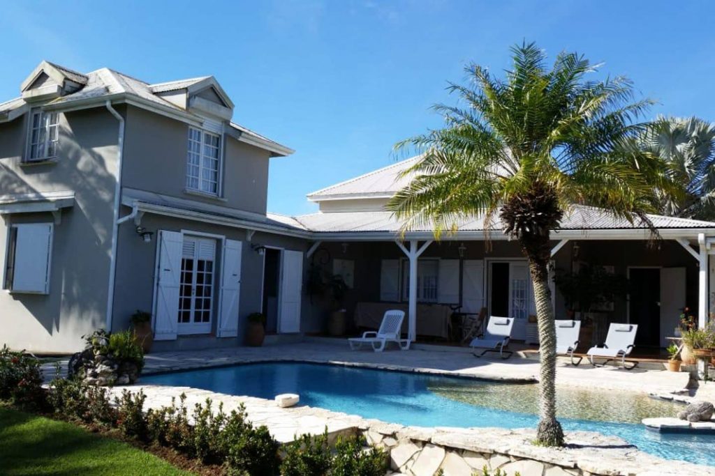 Villa  Louise , location de vacances de prestige en Guadeloupe. Piscine à sel avec cocotiers dans un grand jardin tropical.
