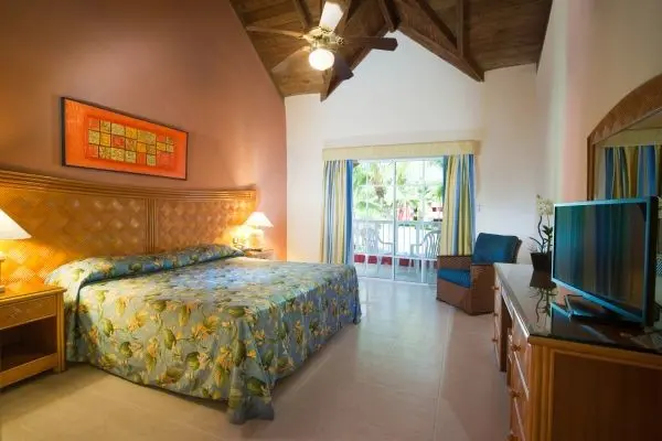 Pour un séjour pas cher en Réûblique Dominicaine en forfait tout compris profitez de la promo. Chambre de l'hôtel Maxi Club à Punta Cana avec lit double, terrasse et vue sur la plage. Offre de voyage tout inclus d'une semaine .