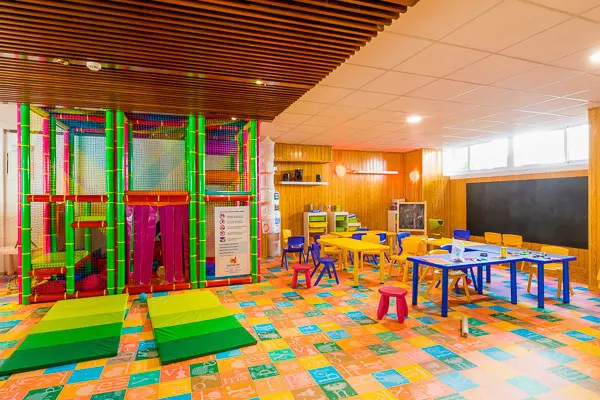 Parc de loisir pour enfant  avec des jeux  et des tables + chaises . Lieu de loisir avec feutres et crayon de couleur pour que les enfants puissent jouer.