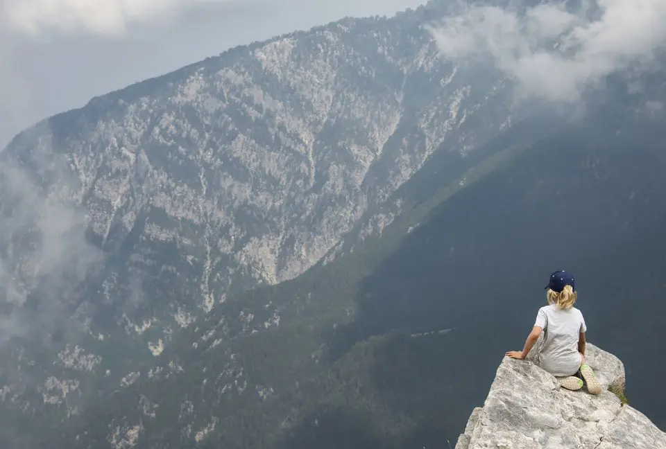 Enfant au sommet du mont Olympe en Grèce . Il admire le paysage et les montagnes.