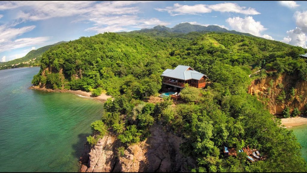 Gite de vacances Secret Bay à la Dominique située au sommet d'une colline avec piscine . Etablissement de vacances en bois , architecture créole proche de la plage .