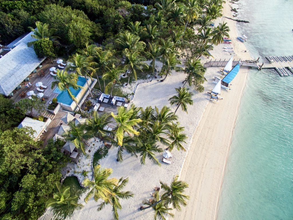 Vue aérienne de l'hôtel Tiamo Resort aux Bahamas . Hôtel de luxe avec piscine extérieure face à la mer et des cocotiers , palmiers . 
